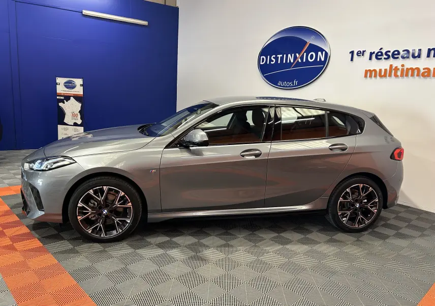 BMW Série 1 120DA M Sport gris Skyscrap vue de profil côté gauche en intérieur showroom avec jantes noires.