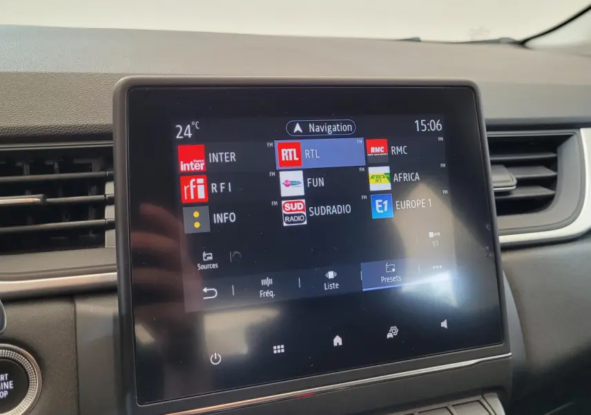 Écran tactile central du tableau de bord du Renault Captur gris clair, affichant les stations radio FM.