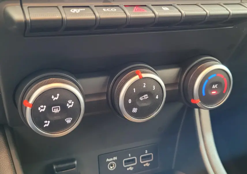 Gros plan sur les commandes de climatisation et ventilation du tableau de bord du Renault Captur gris clair 2021.