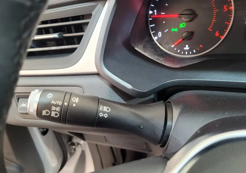 Gros plan sur la commande des phares et clignotants du tableau de bord gris du Renault Captur Business Blue dCi 95 2021.