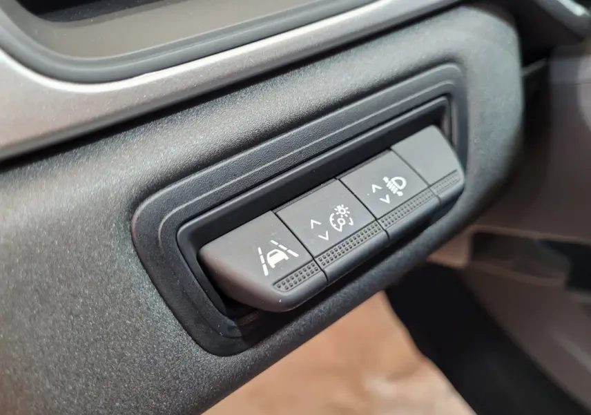 Gros plan sur les boutons de réglage d'assistance et éclairage du tableau de bord du Renault Captur Business gris clair 2021.