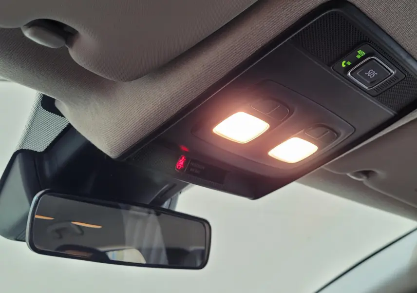 Plafonnier allumé avec boutons SOS et rétroviseur intérieur dans un Renault Captur gris clair 2021.