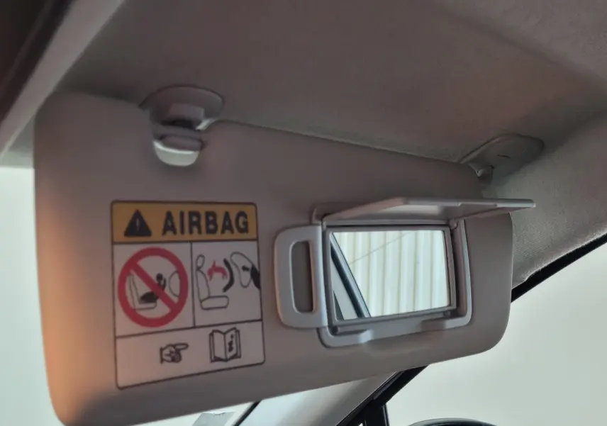 Miroir de courtoisie ouvert sur pare-soleil côté conducteur d'un Renault Captur gris clair 2021, intérieur lumineux.