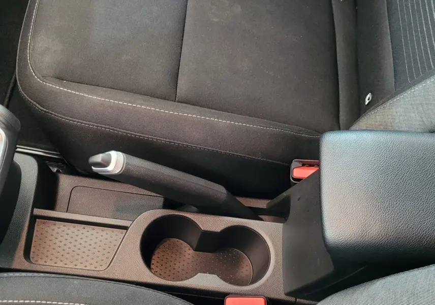 Vue plongeante sur la console centrale noire du Renault Captur 2021 avec frein à main manuel et porte-gobelets.