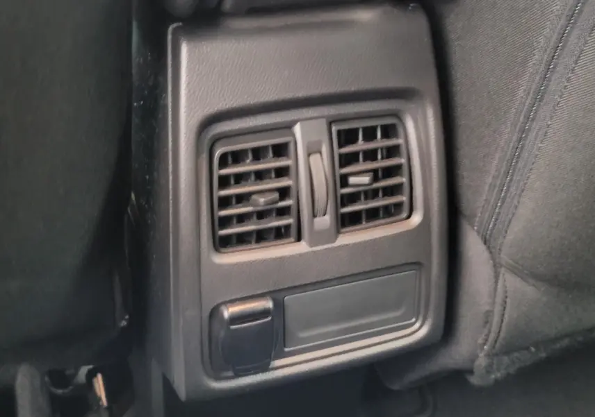 Détail des bouches d'aération arrière et prise 12V dans l'habitacle noir du Renault Captur Business 2021.