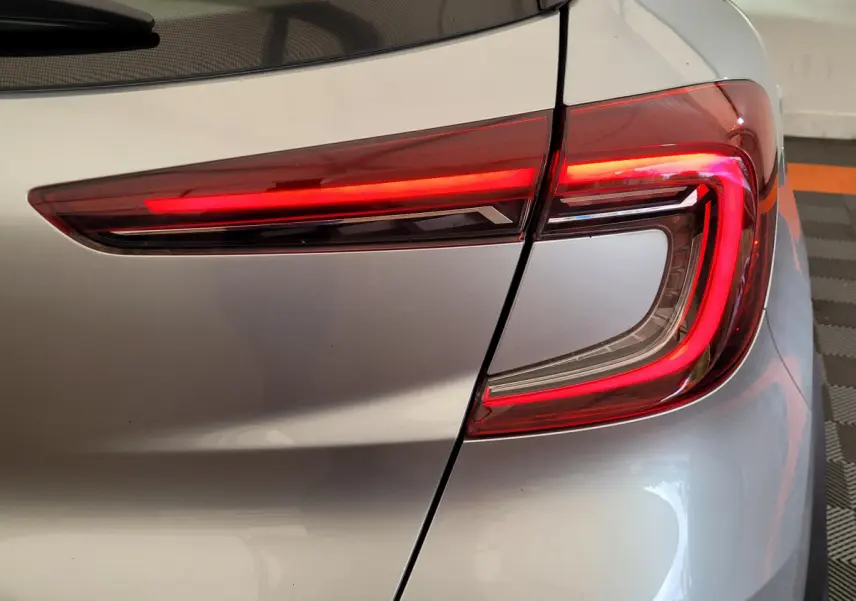 Gros plan sur le feu arrière droit rouge d'un Renault Captur Business gris clair 2021 dans un garage.
