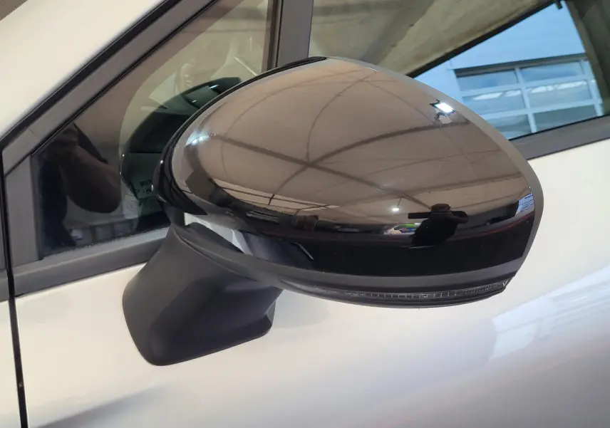 Rétroviseur extérieur droit noir brillant du Renault Captur gris clair, vue rapprochée sur porte côté conducteur.