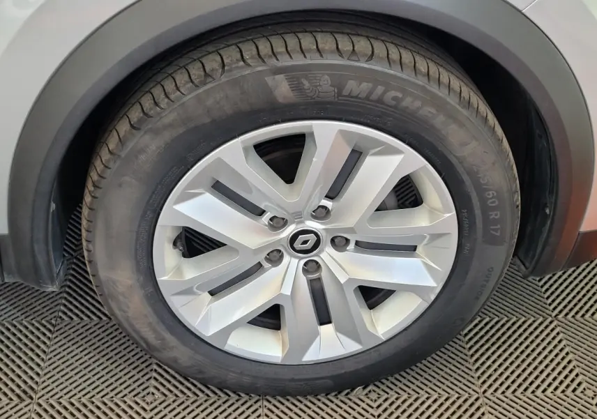 Gros plan sur la roue avant droite du Renault Captur gris clair, avec jante alliage et pneu Michelin visible.