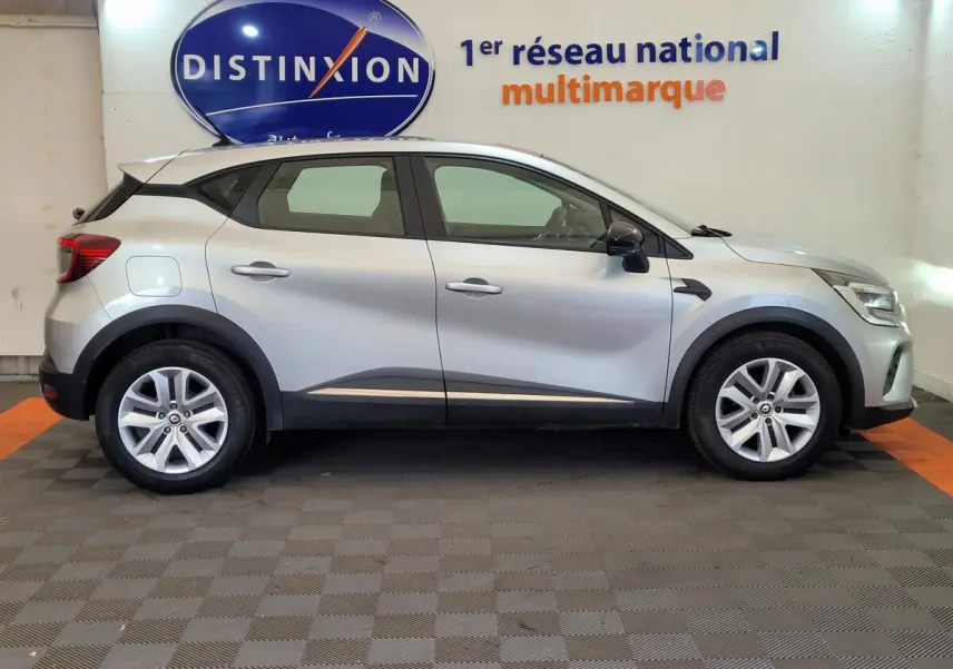 Profil côté droit d'un Renault Captur Business gris clair 2021, avec jantes alliage et protections noires sur les passages de roues.