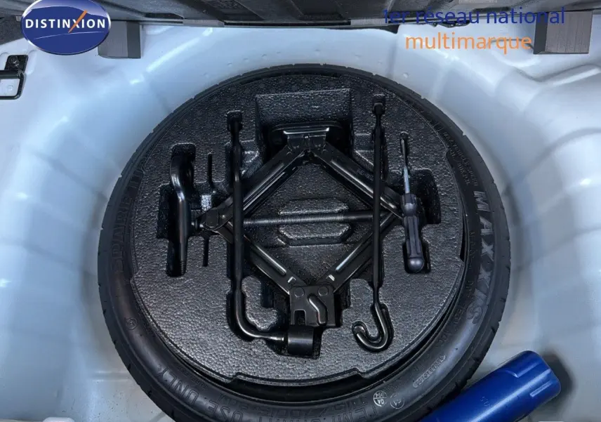 Vue plongeante sur la roue de secours et les outils de bord dans le coffre d'une Hyundai i10 blanche 2018