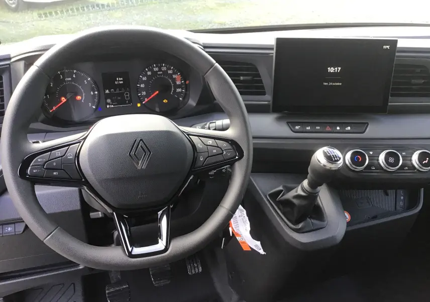 Vue intérieure du tableau de bord du Renault Master 2025, avec volant multifonction, écran tactile central et levier de vitesse manuel.