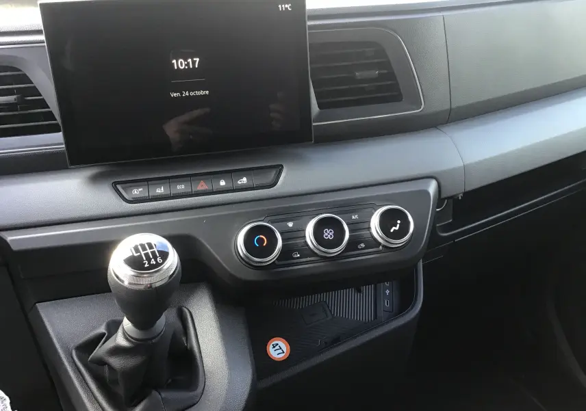 Intérieur du Renault Master 2025 gris urbain, vue sur la console centrale avec boîte manuelle et écran tactile GPS.
