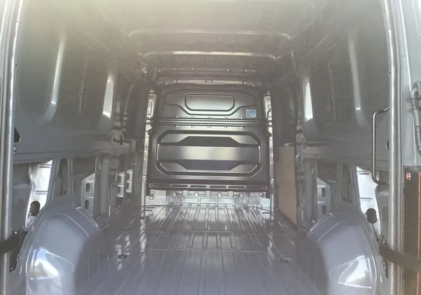Vue intérieure de la zone de chargement du Renault Master L3H2 gris urbain, montrant l'espace vide et la cloison arrière.