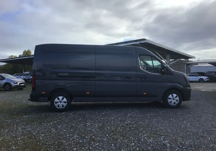 Vue latérale droite d’un Renault Master L3H2 gris urbain 2025, fourgon utilitaire avec jantes acier et feux latéraux orange.