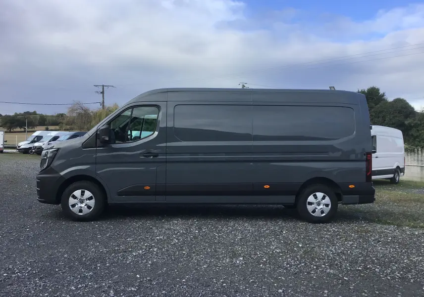 Vue de profil côté gauche du Renault Master L3H2 gris urbain 2025, avec marquages latéraux et feux arrière visibles.