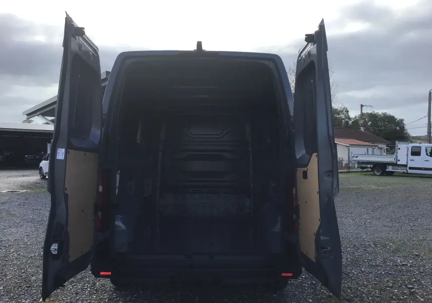 Vue arrière du Renault Master gris urbain 2025 avec portes ouvertes, montrant l'espace de chargement vide et le marchepied arrière.