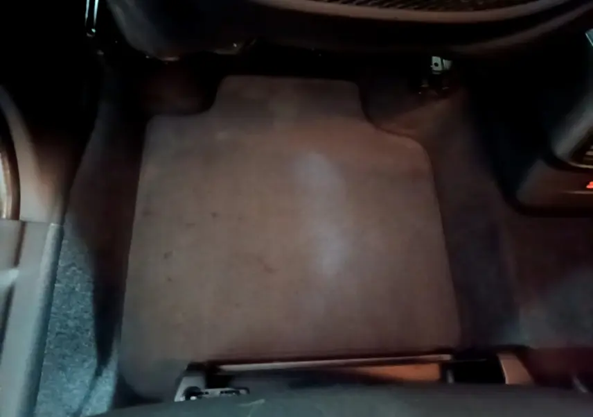 Vue rapprochée du tapis de sol côté passager avant d’une BMW Série 2 Gran Tourer gris clair, intérieur sombre.