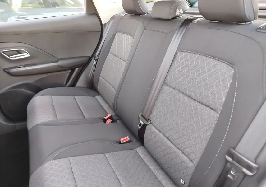 Vue intérieure côté droit des sièges arrière gris tissu du MG Motor ZS 1.5L Hybrid+ 2026 avec ceinture de sécurité noire.