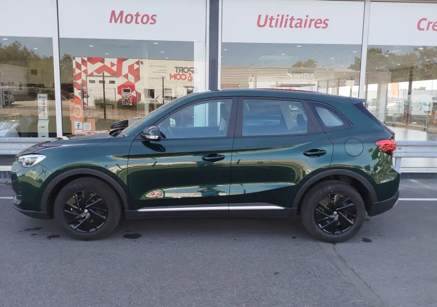Vue de profil côté gauche d’un MG ZS Emerald Green Metal 2026, avec jantes noires et détails chromés sur le bas de caisse.