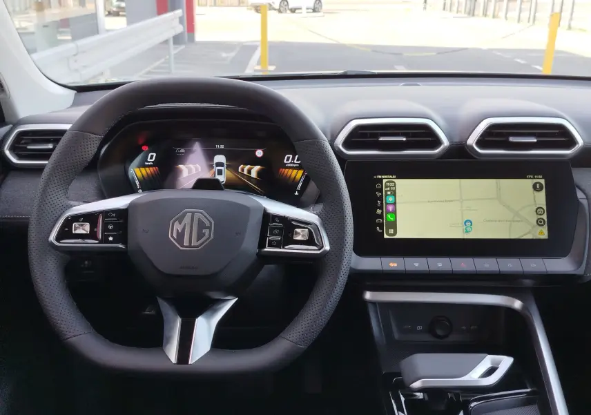 Vue intérieure du tableau de bord MG ZS 2026, volant multifonction noir et écran tactile avec navigation affichée.