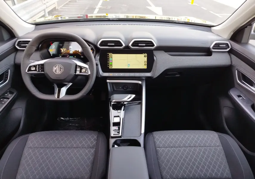 Vue intérieure avant du MG ZS 2026, tableau de bord noir avec écran tactile central et volant multifonction.