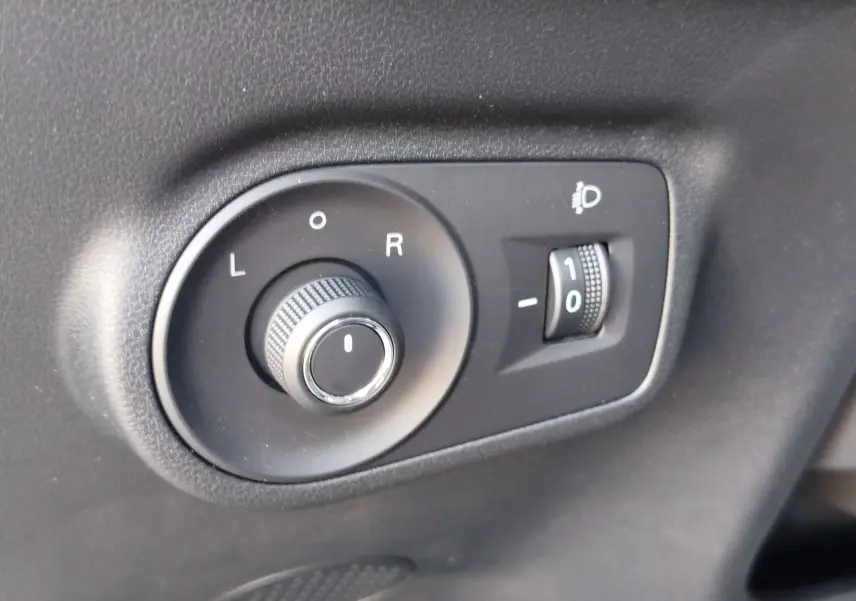 Gros plan sur les commandes noires de réglage des rétroviseurs et de l’éclairage du tableau de bord dans un MG Motor ZS 2026.