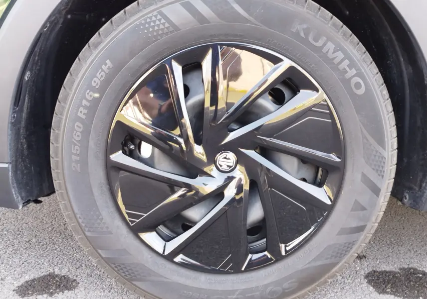 Gros plan sur la roue avant gauche du MG ZS 1.5L Hybrid+ 2026 en Emerald Green Metal, jante noire brillante au design moderne.