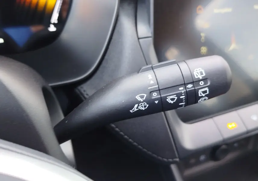 Gros plan sur la commande des essuie-glaces à gauche du volant dans l'habitacle noir du MG Motor ZS hybride 2026.