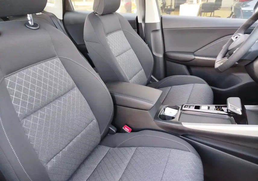 Vue intérieure côté droit du MG ZS 2026, sièges tissu gris avec surpiqûres et console centrale moderne noire.