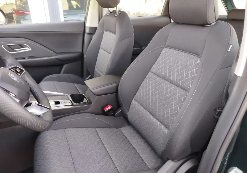 Vue intérieure côté gauche du MG ZS 2026, sièges tissu gris avec surpiqûres et volant cuir perforé.
