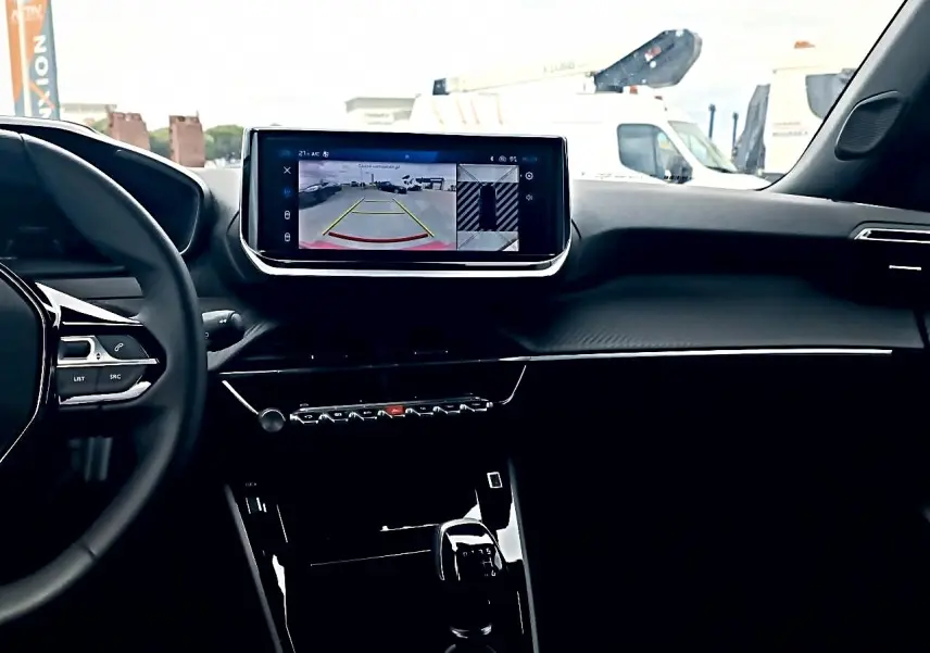 Vue intérieure du tableau de bord et écran tactile central du Peugeot 2008 rouge elixir 2025, avec caméra de recul affichée.