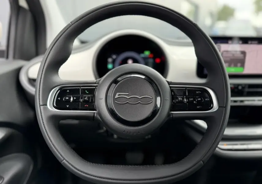Volant noir Soft-Touch de Fiat 500 électrique 2024, vue frontale centrée avec tableau de bord blanc Artic en arrière-plan.