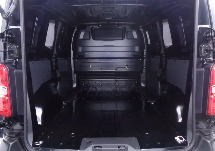 Vue intérieure arrière du fourgon Peugeot Expert Standard 2022 noir métal, montrant l'espace de chargement vide et les portes ouvertes.