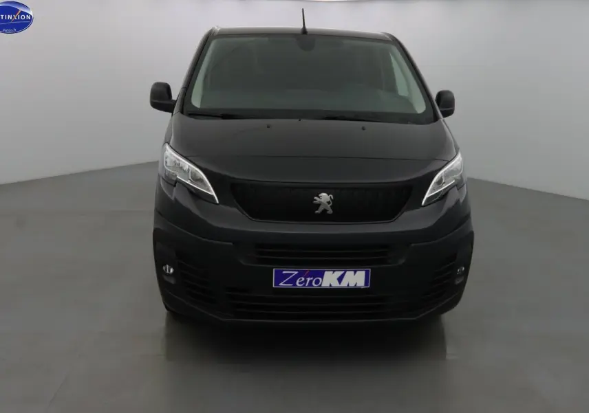 Peugeot Expert Fourgon noir métal vu de face dans un studio, avec logo lion et plaque Zero KM visible.