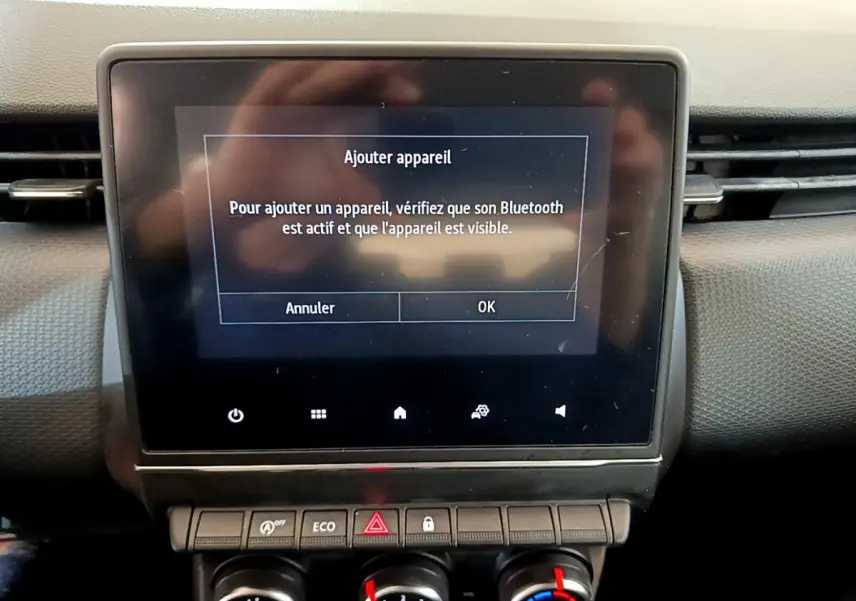 Écran tactile central affichant l'ajout d'appareil Bluetooth dans l'habitacle noir d'une Renault Clio Business 2020.