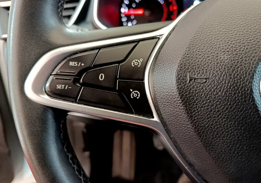 Gros plan sur le volant noir de la Renault Clio Business Blue dCi 85, avec commandes de régulateur de vitesse visibles à gauche.