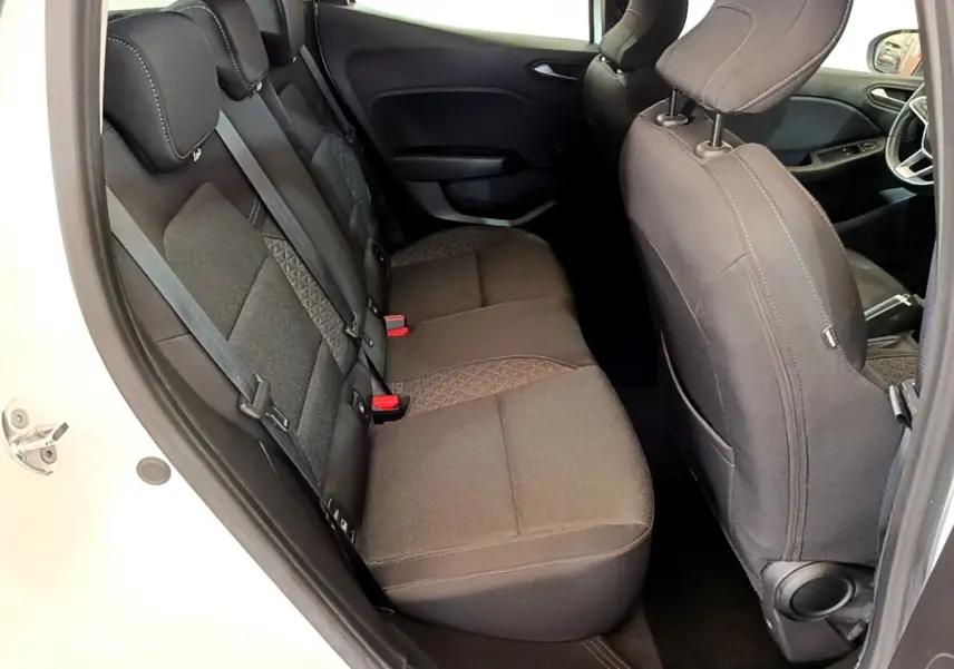 Vue intérieure côté gauche montrant la banquette arrière noire et les sièges avant d'une Renault Clio Business Blue dCi 85 blanche.
