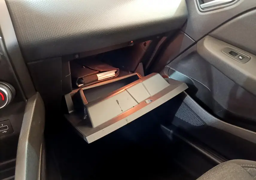 Vue intérieure côté passager de la boîte à gants ouverte dans une Renault Clio Business Blue dCi 85 noire.