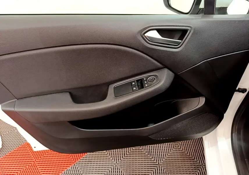 Vue intérieure côté gauche de la porte avant blanche de la Renault Clio Business avec commandes électriques des vitres.