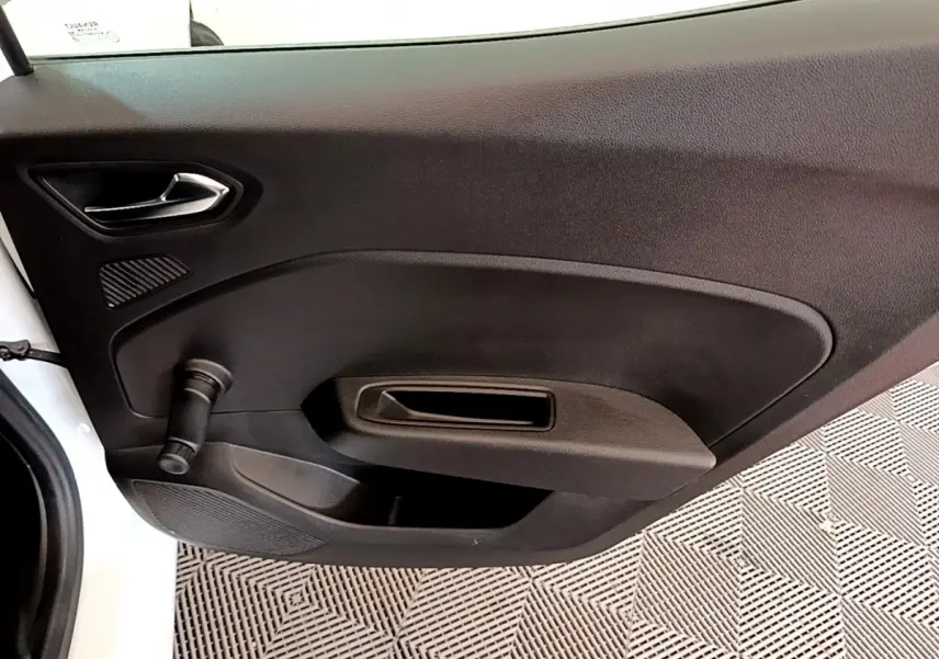 Vue intérieure côté gauche de la porte avant blanche d'une Renault Clio Business avec poignée manuelle de vitre.