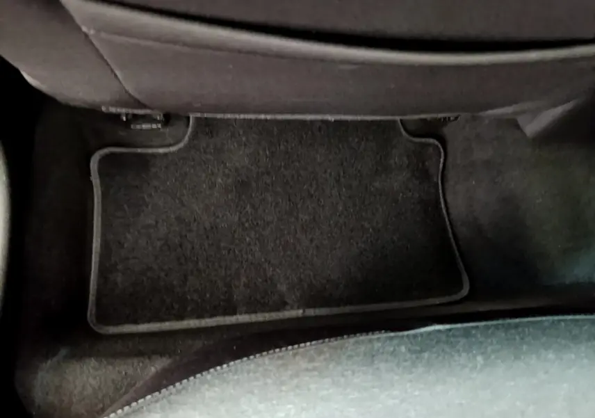 Vue rapprochée du tapis de sol noir côté passager arrière d’une Renault Clio Business Blue dCi 85 blanche de 2020.