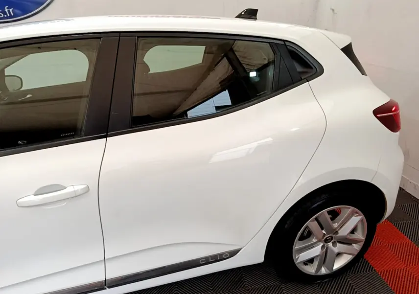 Vue latérale droite d'une Renault Clio blanche 2020 avec jantes alliage et poignées de porte intégrées.