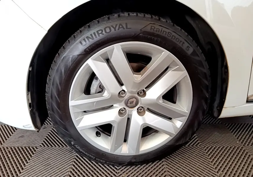 Gros plan sur la roue avant droite blanche d'une Renault Clio Business Blue dCi 85 avec jante alliage argentée.