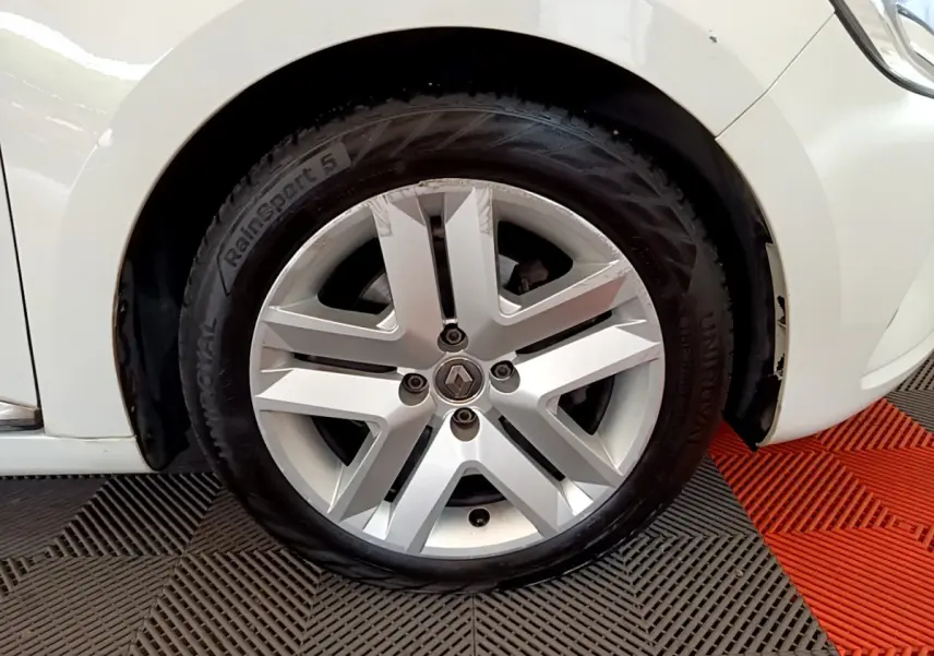 Gros plan sur la roue avant droite blanche d'une Renault Clio Business Blue dCi 85 avec jante alliage argentée.
