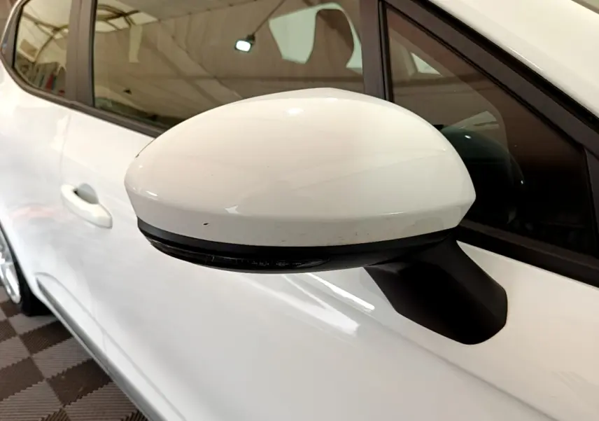 Gros plan sur le rétroviseur droit blanc d'une Renault Clio Business Blue dCi 85 2020, avec porte et vitre arrière visibles.