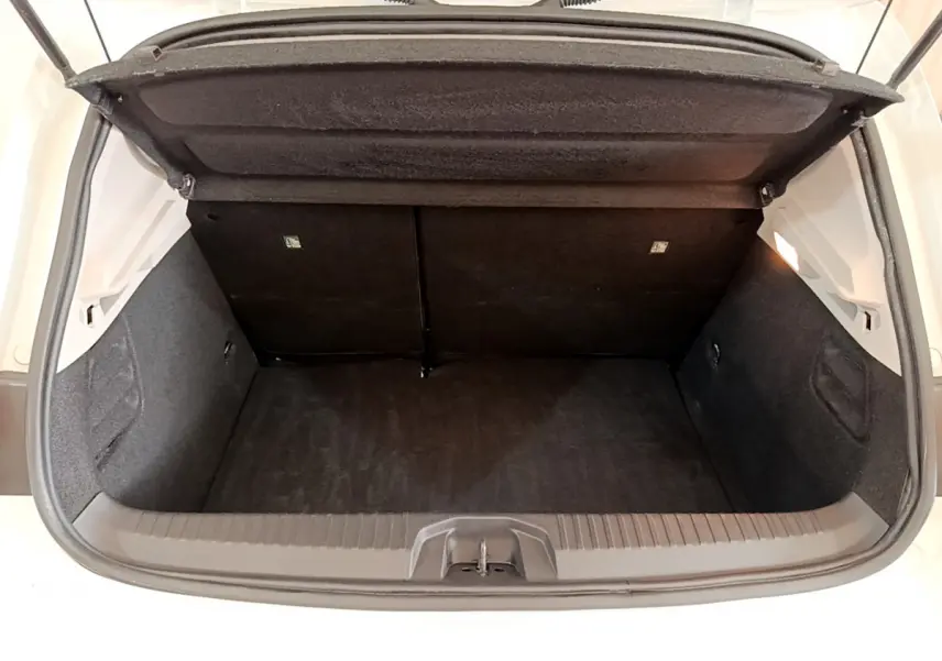 Coffre ouvert vu de l'arrière d'une Renault Clio Business Blue dCi 85 blanche, espace de chargement vide et propre.