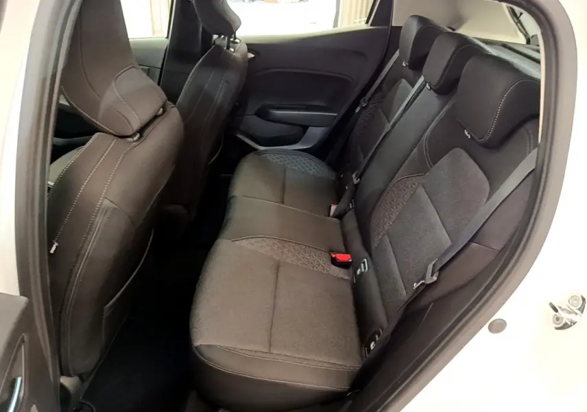 Vue intérieure arrière côté droit de la Renault Clio Business Blue dCi 85 blanche, sièges tissu noirs avec surpiqûres grises.