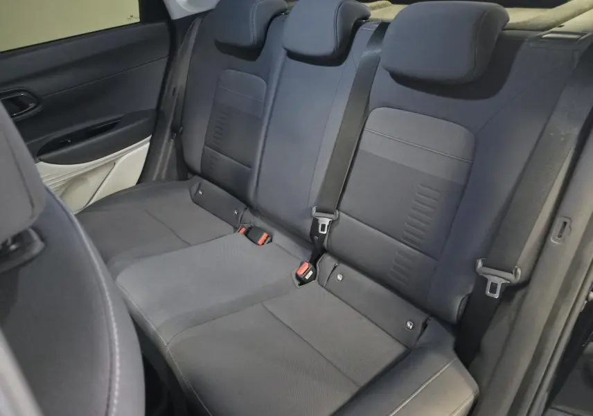 Vue intérieure des sièges arrière noirs du Hyundai Bayon 2025, avec ceintures de sécurité et appuie-têtes réglables.