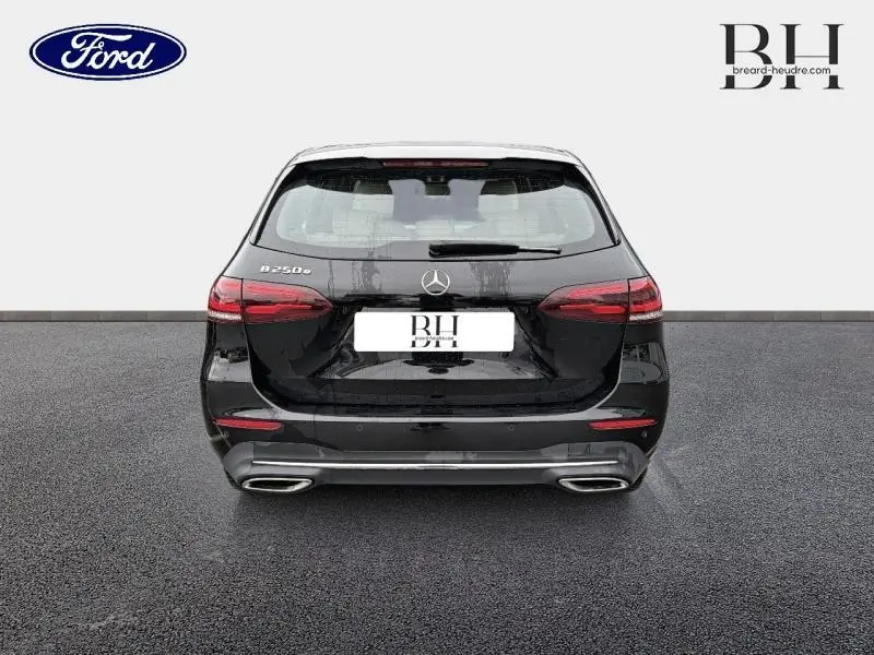 Vue arrière d'une Mercedes Classe B 250e noire cosmos métallisé avec hayon EASY-PACK et double sortie d'échappement chromée.