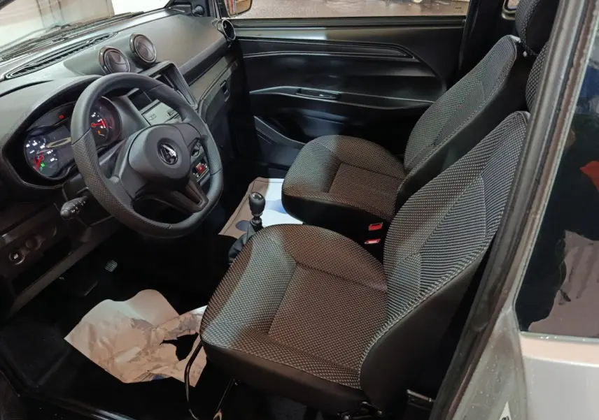 Vue intérieure côté conducteur de l'AIXAM AMBITION 0.5 CITY PACK 2026, sièges gris et tableau de bord noir.